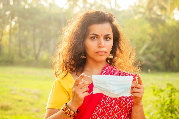 Portrait d'une jeune femme indienne portant un masque le concept de santé et de sécurité du tourisme dans les pays asiatiques et indiens