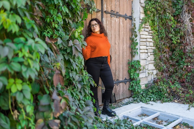 Portrait d'une jeune femme insouciante souriante avec une grande porte en arrière-plan joyeuse fille latine portant des lunettes