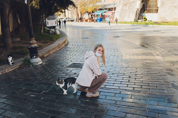 Portrait de jeune femme jouant avec un chat dans la rue de la ville.