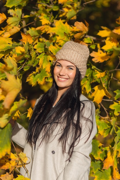 Portrait d'une jeune femme joyeuse appréciant dans le parc en automne.