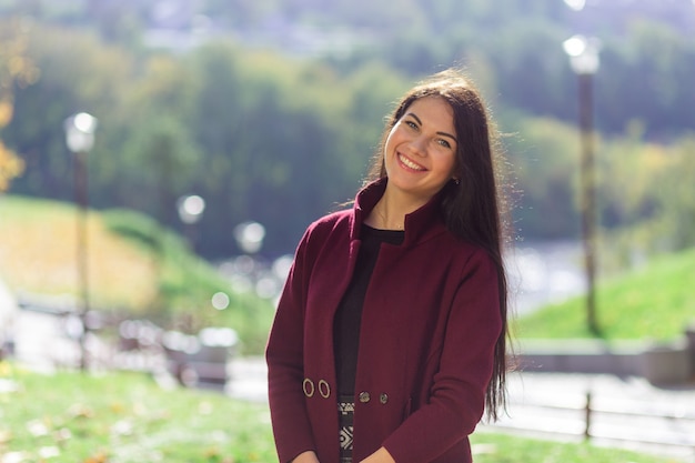 Portrait d'une jeune femme joyeuse appréciant dans le parc en automne.