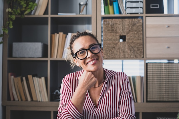 Portrait d'une jeune femme joyeuse souriante s'amusant à la maison. Jolie jeune femme caucasienne étudiant indépendante en regardant la caméra et en posant pour la photo.