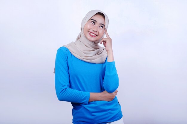 Portrait de jeune femme joyeuse avec t-shirt bleu portant l'expression de la pensée hijab