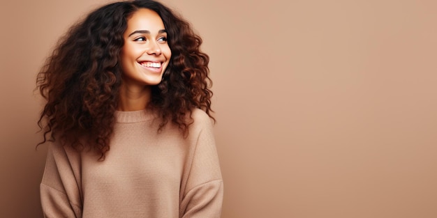 Portrait d'une jeune femme latine avec un sourire agréable sur fond beige avec espace de copie Belle fille en pull chaud