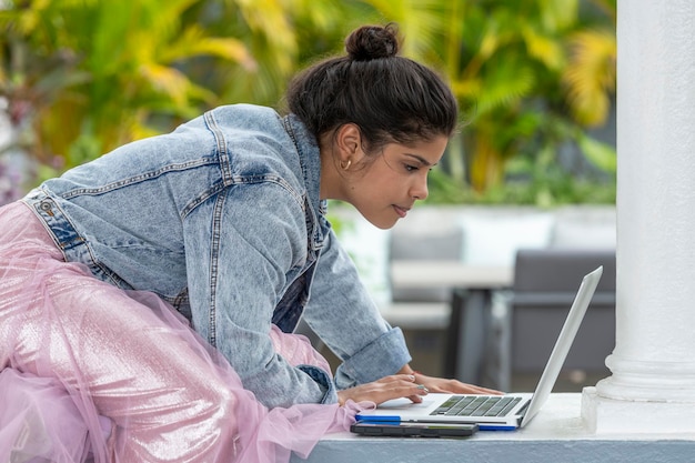 Portrait d'une jeune femme latine utilisant un ordinateur portable à l'extérieur photo stock