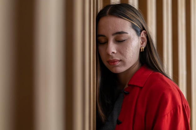 Portrait de jeune femme latino-américaine avec les yeux fermés et une attitude détendue fond de bois