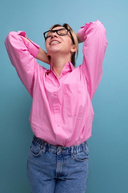 portrait d'une jeune femme leader blonde prospère dans un chemisier rose et des lunettes
