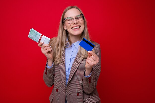 Portrait d'une jeune femme avec une liasse d'argent et une carte de crédit