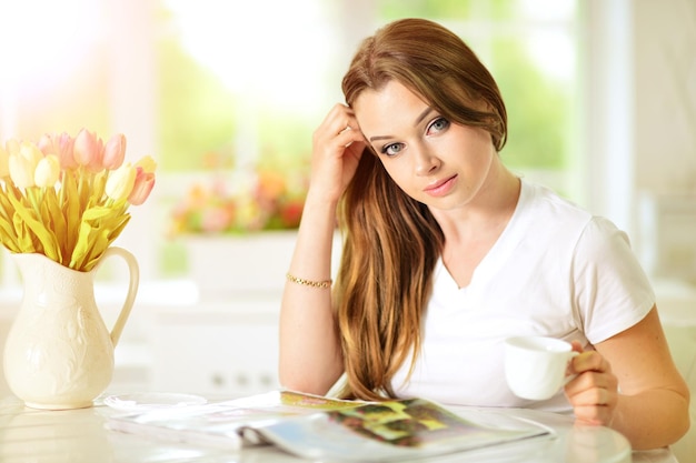 Portrait d'une jeune femme lisant un gros livre intéressant