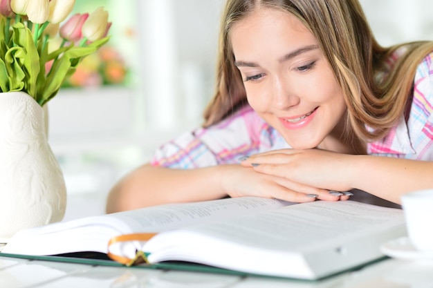 Portrait d'une jeune femme lisant un gros livre intéressant