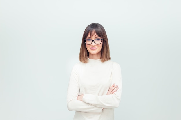 Portrait de jeune femme à lunettes sur blanc