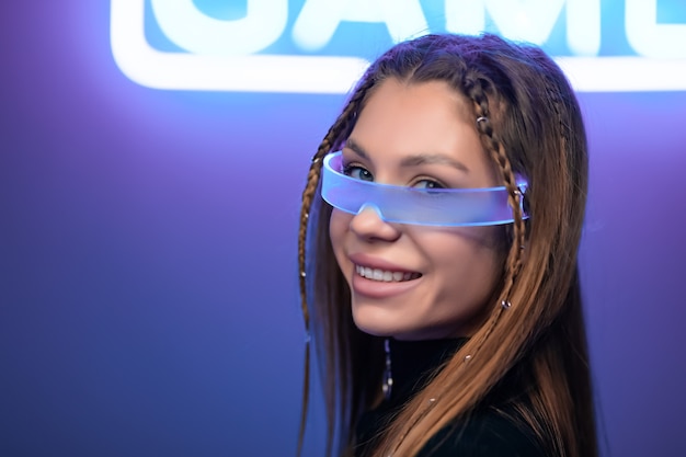 Portrait d'une jeune femme à lunettes néon.