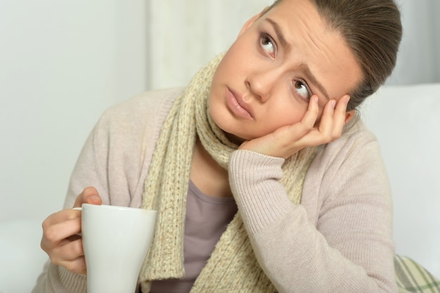 Photo portrait d'une jeune femme malade buvant du thé chaud