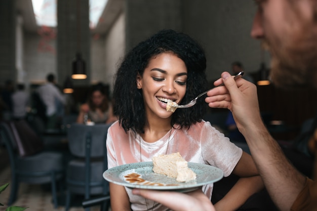 Portrait de jeune femme mangeant un gâteau au restaurant