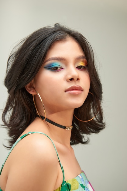 Portrait de jeune femme avec le maquillage coloré d'arc-en-ciel drôle