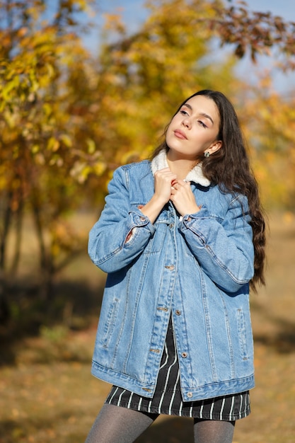 Portrait de jeune femme marchant dehors dans le parc d'automne