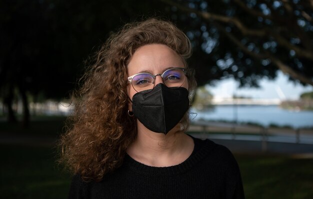 Portrait d'une jeune femme avec un masque dans la rue pendant la pandémie