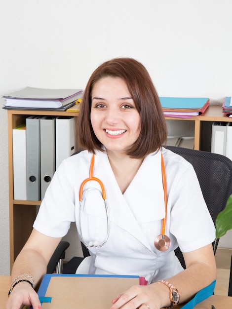 Portrait de jeune femme médecin assis au bureau à l'hôpital