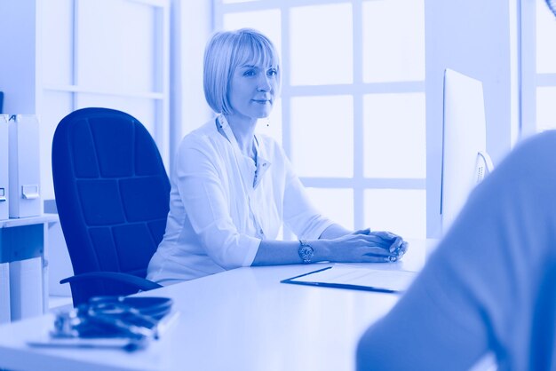 Portrait de jeune femme médecin assis au bureau à l'hôpital