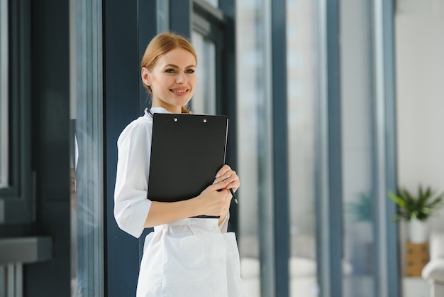 Portrait de jeune femme médecin avec blouse blanche debout à l'hôpital