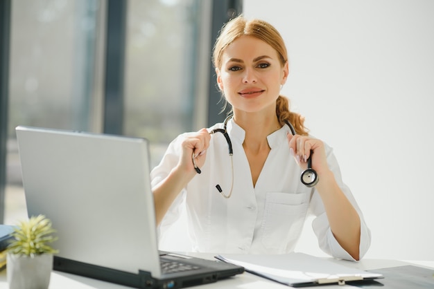 Portrait de jeune femme médecin avec blouse blanche debout à l'hôpital