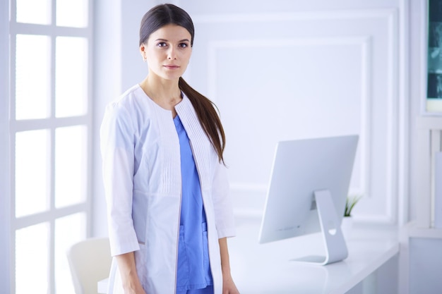 Portrait de jeune femme médecin en blouse blanche debout à l'hôpital