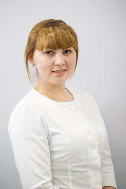 Portrait de jeune femme médecin en costume blanc, gros plan