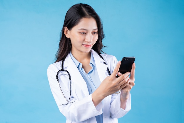 Portrait de jeune femme médecin, isolé sur fond bleu