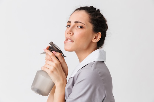 Portrait d'une jeune femme de ménage séduisante habillée en uniforme