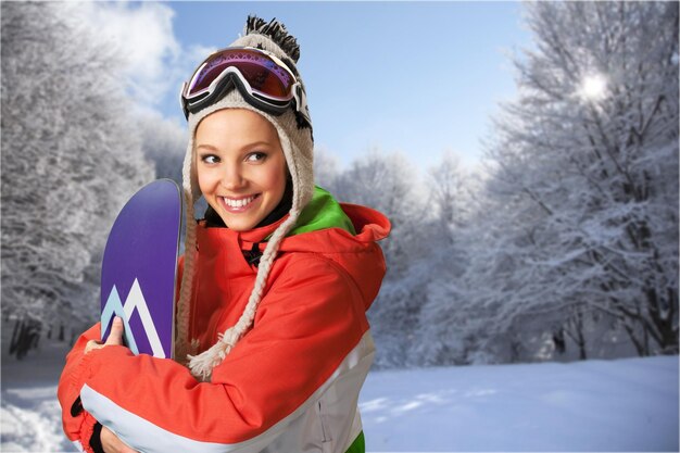 Portrait de jeune femme mignonne avec snowboard sur fond d'hiver