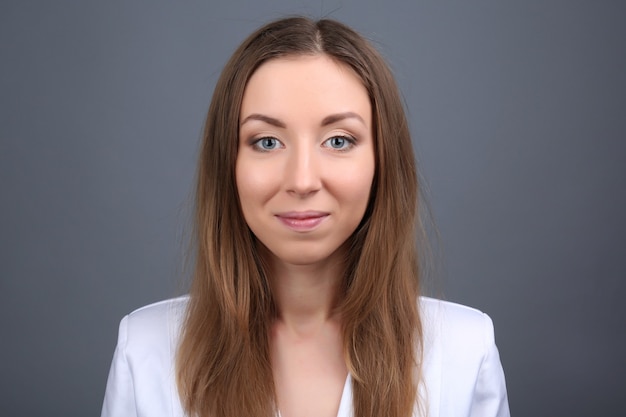 Portrait de jeune femme sur mur gris