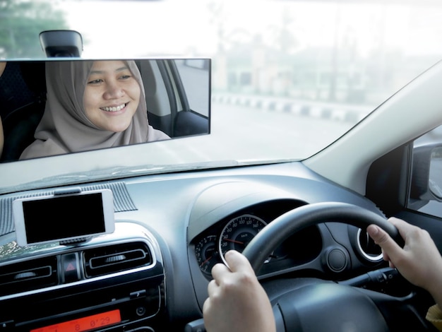 Portrait d'une jeune femme musulmane asiatique souriant et conduisant une voiture beau concept de partage de voiture d'entrepreneur