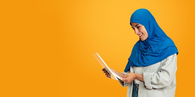 Portrait de jeune femme musulmane sur mur jaune