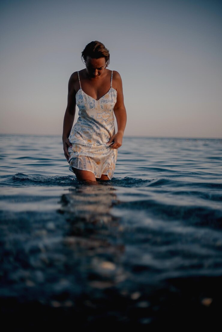 Photo portrait d'une jeune femme nageant dans la mer contre le ciel