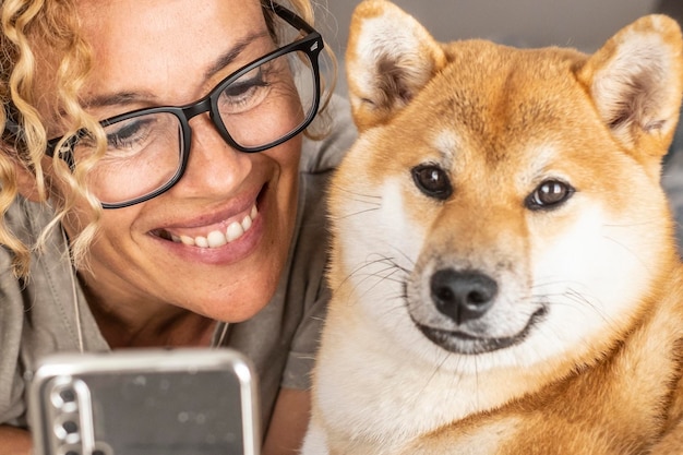 Photo portrait d'une jeune femme noire belle avec son adorable chiot de race pure shiba inu à la maison fille aimante avec un chiot de chien drôle s'amusant sur le canapé arrière-plan espace de copie rapproché propriétaire de l'animal