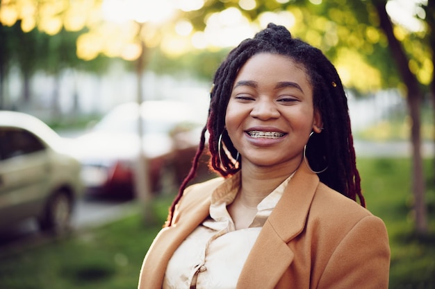 Portrait d'une jeune femme noire debout dans une rue