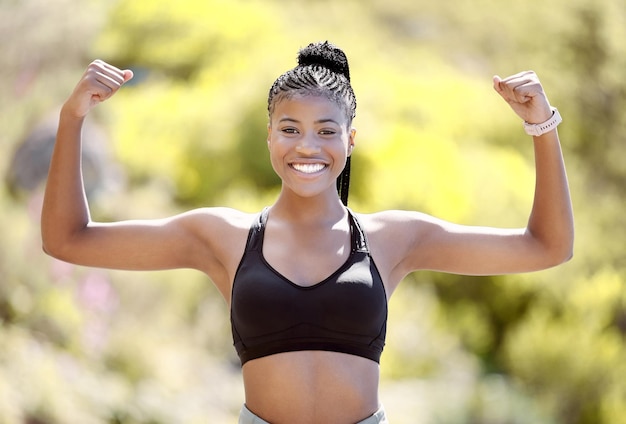 Portrait de jeune femme noire montrant la force physique et les muscles après avoir fait de l'exercice à l'extérieur dans la nature Motivation et entraînement pour femme