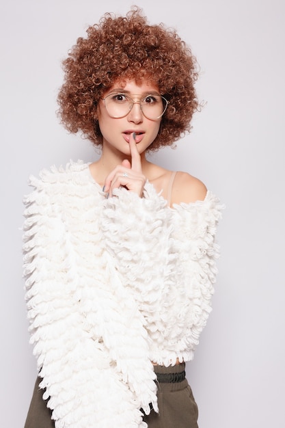 Photo portrait de jeune femme noire souriante. portrait d'une belle jeune femme avec une coupe de cheveux afro-américaine et un maquillage glamour. prise de vue en studio. jolie fille portant des lunettes.