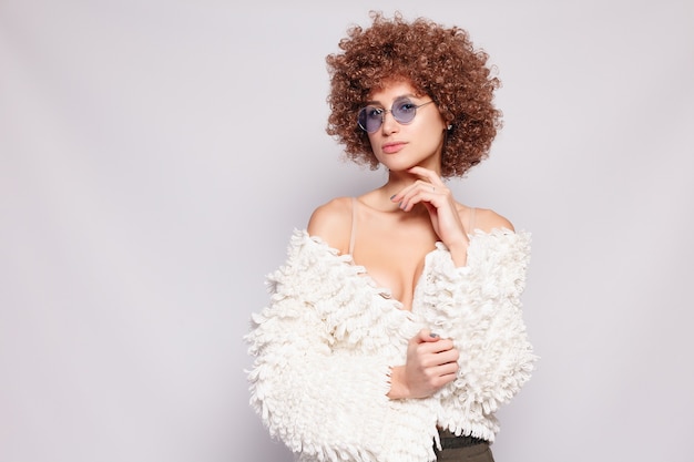 Portrait de jeune femme noire souriante. Portrait d'une belle jeune femme avec une coupe de cheveux afro-américaine et un maquillage glamour. Prise de vue en studio. Jolie fille portant des lunettes.