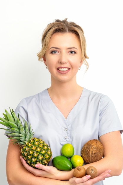 Portrait d'une jeune femme nutritionniste caucasienne souriante avec différents fruits dans ses mains