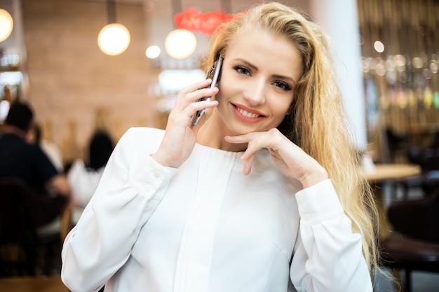 Portrait d'une jeune femme parlant au téléphone pendant une pause