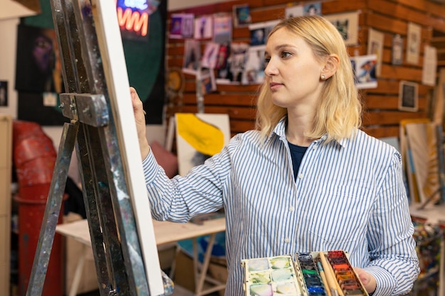 Portrait d'une jeune femme peignant un tableau