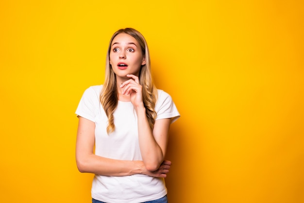 Portrait de jeune femme pense que les pensées touchent les mains du menton isolés sur un mur de couleur vive