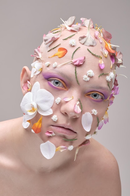 Portrait d'une jeune femme avec des pétales sur le visage