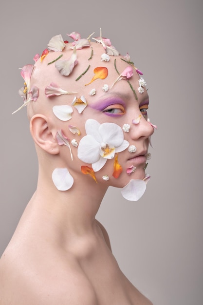 Portrait d'une jeune femme avec des pétales sur le visage