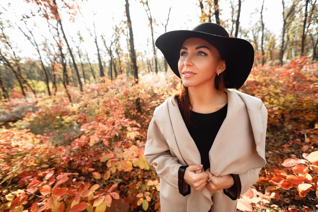 Photo portrait d'une jeune femme portant un chapeau contre les arbres