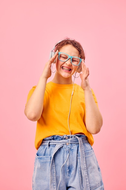 Portrait d'une jeune femme portant des lunettes bleues écoutant de la musique sur des écouteurs