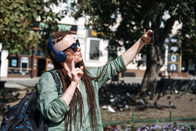 Photo portrait d'une jeune femme portant des lunettes de soleil alors qu'elle se tient à l'extérieur