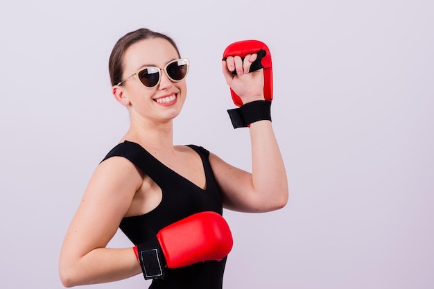 Photo portrait d'une jeune femme portant des lunettes de soleil sur un fond blanc