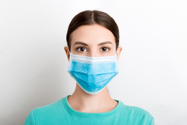 Portrait de jeune femme portant un masque médical au mur blanc. Protégez votre santé. Concept de coronavirus